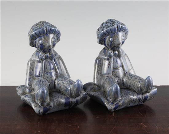 A pair of Clarice Cliff golly blue mottle glazed bookends, height 15.5cm, one damaged